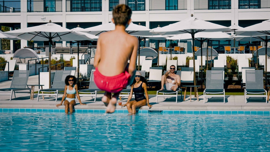 A boy performing a cannon ball into the pool