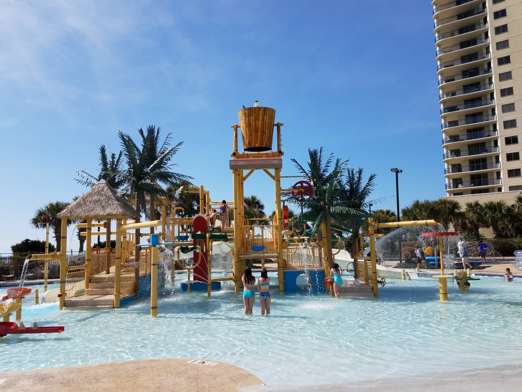 A waterpark splash bucket with two children playing.