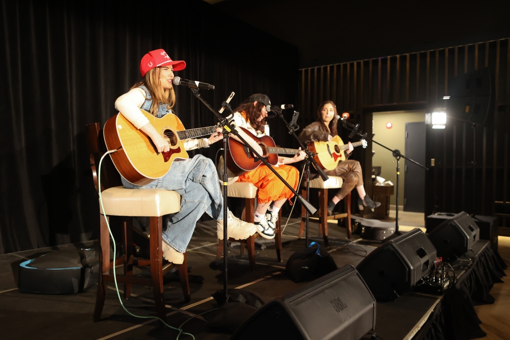 3 guitarists/singers on stage in Seaside Vista performing